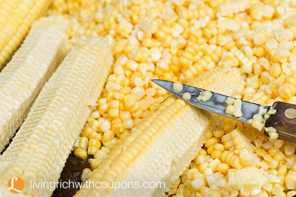 Cutting kernels of fresh homegrown sweetcorn to prepare for freezing..